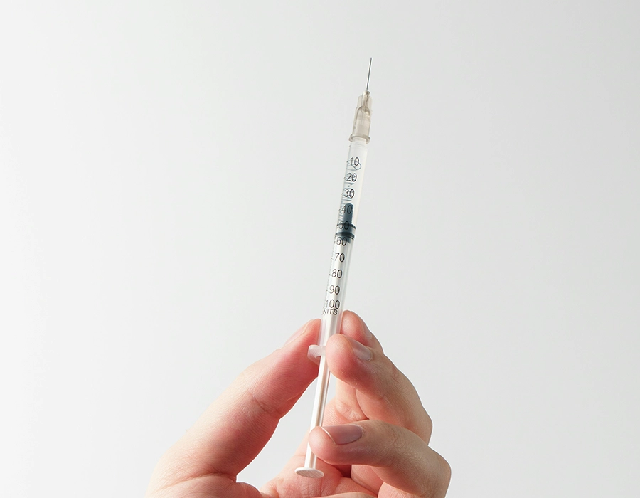 a hand holding a syringe