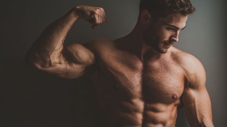 A man flexing his muscles in the studio