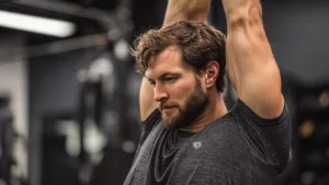 man stretching his arms above his head